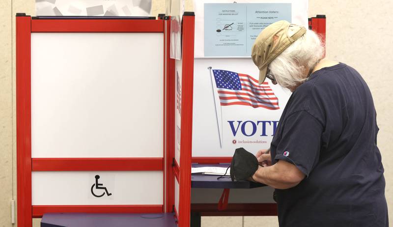 Shaw Local June 2022 file photo – Caroline Bushong, from DeKalb, casts her ballot on the first day of the early voting period Thursday, May 19, 2022, at the polling place at the DeKalb County Legislative Center in Sycamore.