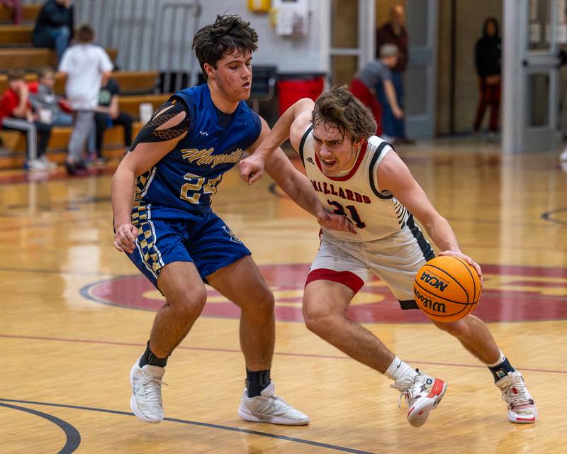 Henry-Senachwine's Carson Rowe (21) tries to drive past Marquette's Matt Graham (24) in Friday's Tri-County Conference game in Henry.