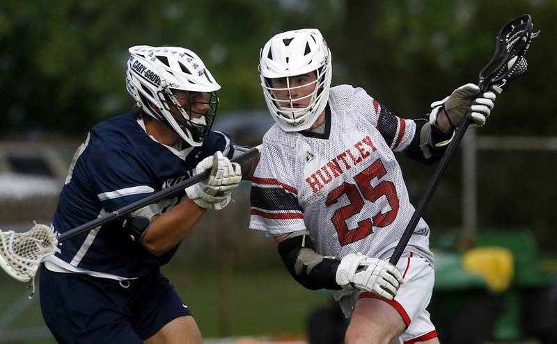 Huntley's Bobby Pupich (right) battles with Cary-Grove's Oliver Antonelli for position during the Marian Central Sectional boys lacrosse semifinal match on Wednesday, May 28, 2025, at Marian Central High School in Woodstock.