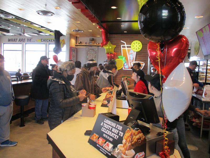 Staff at Raising Cane's Chicken Fingers take customer orders Tuesday, March 8, 2022 on opening day for the restaurant at 3000 Plainfield Road in Joliet.