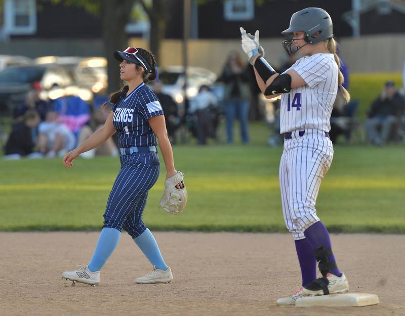 Downers Grove North’s Ella Bonk (14) celebrates her double on second base as Downers Grove South’s Natalia Manganello looks towards action at home plate during a game on May 14, 2026 at McCollum Park in Downers Grove .