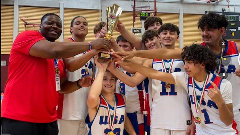 Dixon rising junior Darius Harrington (second from left) and Sterling rising junior Nico Battaglia (third from right) hoist the 16U United World Games championship trophy with their PhD Hoops USA teammates and coach on June 25, 2023.