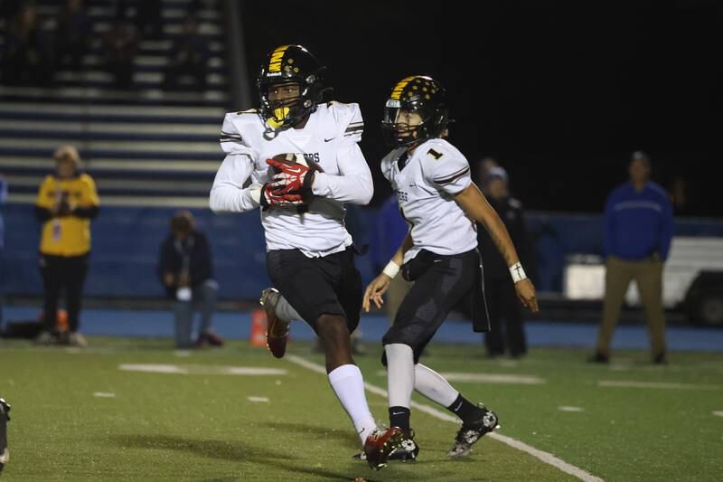 Joliet West’s Jordan Bennett takes the handoff from Antoine Brooksagainst Lyons Township in the first round of the playoffs on Friday, Nov. 1, 2024 in La Grange.