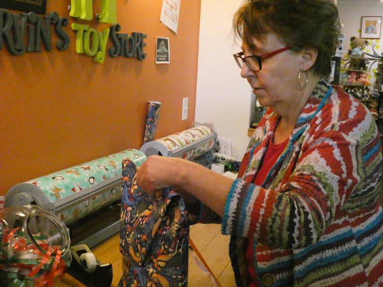 Lori McConville, owner of Marvin's Toy Store in Crystal Lake, wraps a gift behind the counter on Thursday, Dec. 1, 2022.