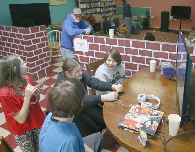 Jeff VanAutreve (top) watches teenagers gather and play video games inside the Second Story Teen Center on Tuesday, Dec. 5, 2023 in Princeton. Fundraising for the new building has just passed it's halfway mark.