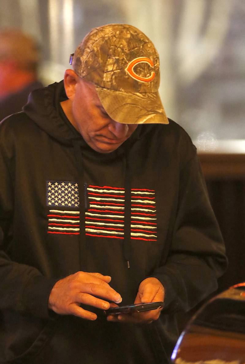 Rich Cain, the husband of Connie Cain, a candidate for Illinois state representative in District 66, looks at election results on his smartphone during a Republican election night watch party Tuesday, Nov. 8, 2022, at Niko's Red Mill Tavern, 1040 Lake Ave. in Woodstock. The event was hosted by Illinois State Sen. Craig Wilcox, McHenry County Board Chairman Mike Buehler, McHenry County Coroner Michael Rein, and McHenry County Clerk Joe Tirio.