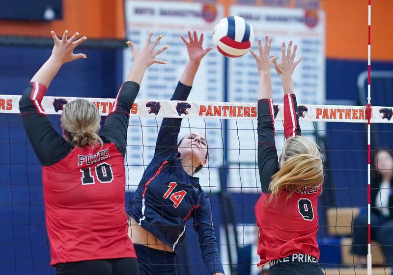 Oswego’s Mia Jurkovic (14) goes up for a kill against Yorkville's Joey Wolgast (18) and Lili Casbarian (9) during a volleyball match at Oswego High School on Thursday, Sept. 14, 2023.