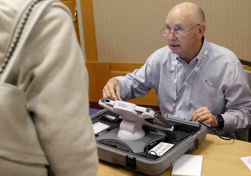 Election judge Tom Reichardt checks in a voter on Tuesday, April 4, 2023, during the 2023 consolidated election at Del Webb Sun City’s Prairie Lodge in Huntley.
