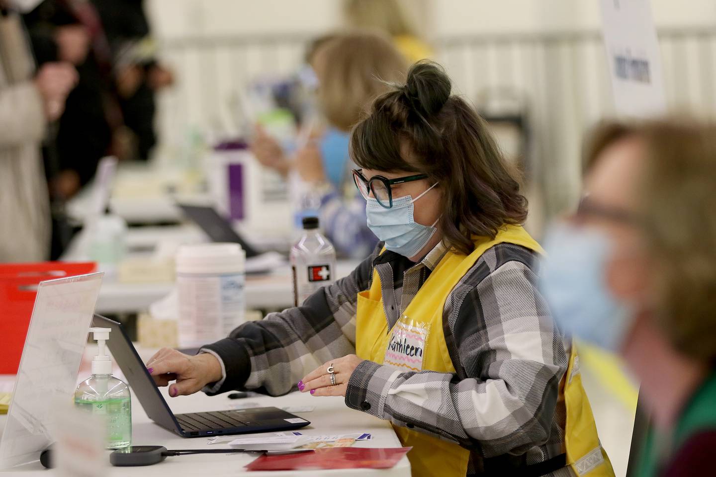 Workers check in people with appointments Tuesday, March 2, 2021, during a COVID-19 vaccination clinic through the McHenry County Department of Health at 1900 N. Richmond Road, the former site of a Kmart in McHenry. Vaccinations are made by appointment only.