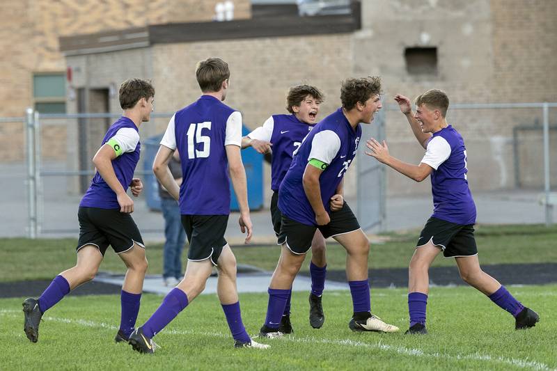 Dixon’s Jayvian Herwig (middle) celebrates with his teammates after scoring a second penalty kick goal against Winnebago Thursday, Sept. 26, 2024, at Dixon High School.