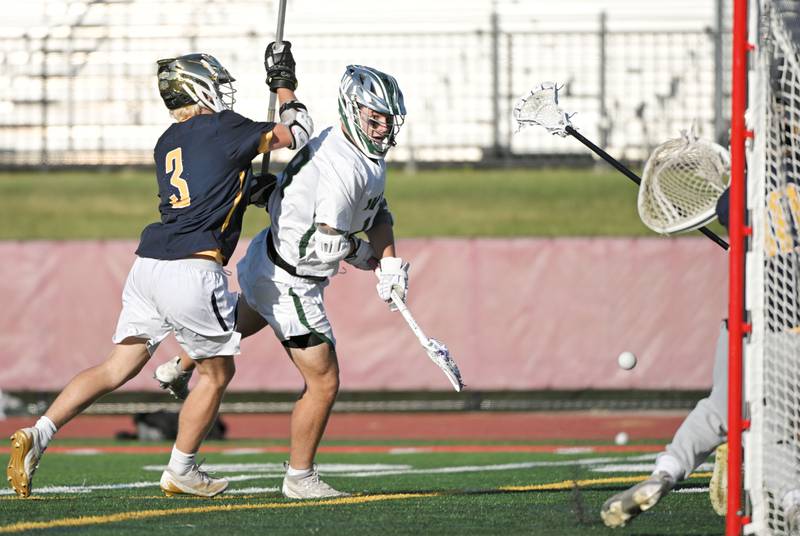 Glenbard West’s Dylan Goerig tries to bounce a shot into the net as he is guarded by Neuqua Valley’s Luke Brosnan in the boys lacrosse state semifinal game in Hinsdale on Thursday, May 30, 2024.