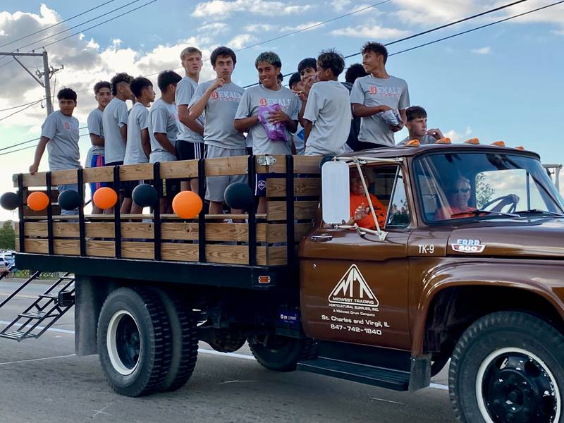 Members of the DeKalb boys soccer team throw candy to eager onlookers during the annual DeKalb High School Homecoming Parade on Wednesday, Sept. 24, 2025, along West Dresser Road.
