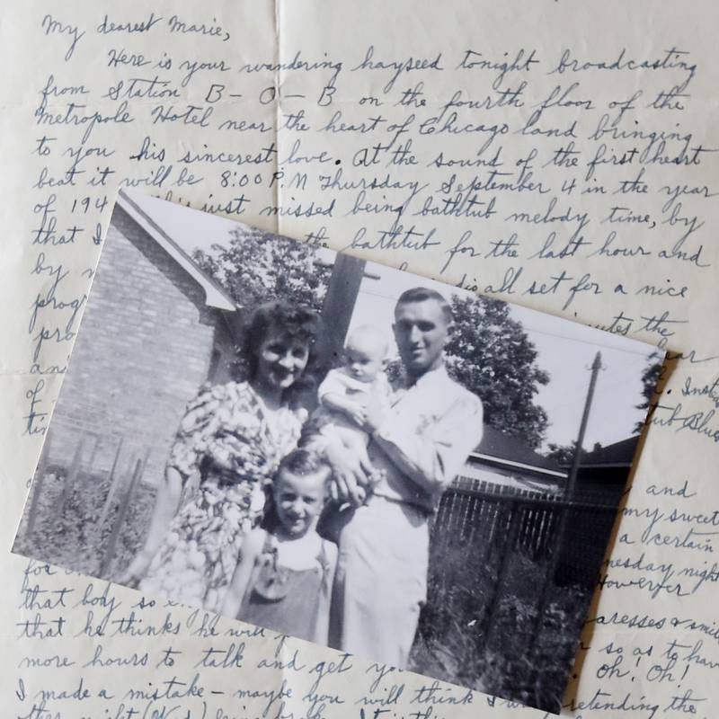 A photograph of Art Peterson; his mother, Marie; father, U.S. Army Air Forces Staff Sgt. Robert E. Peterson; and half brother, Bobby, lays on a letter his father wrote to his mother during World War II. Peterson, a retired journalist, wrote a book based on the letters.