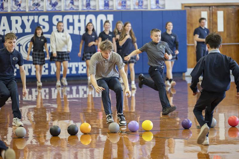 Students race to the center to gather up their dodgeball ammo Monday, Jan. 26, 2026 during the Deanery Dodgeball tournament.