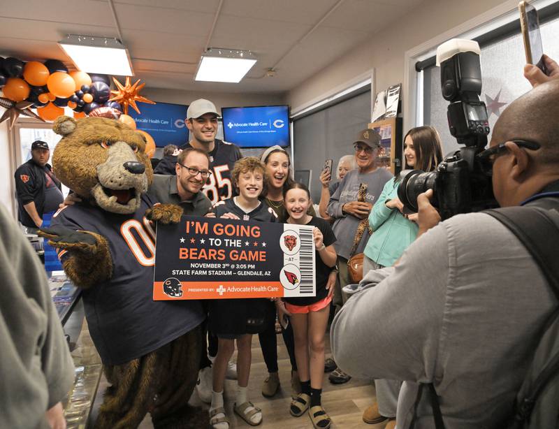 Jonah Davis, a 14-year-old heart patient from Downers Grove poses for photos with his family and Chicago Bears player Cole Kmet and Bears mascot Staley at a surprise party at Mark’s Card Shop in Downers Grove on Tuesday, Oct. 29, 2024.