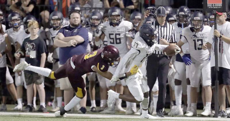 IC Catholic Prep's Antonio Richardson (17) tries to slip past Montini's Eric Melendez (3) during football Friday August 27, 2021 in Lombard.