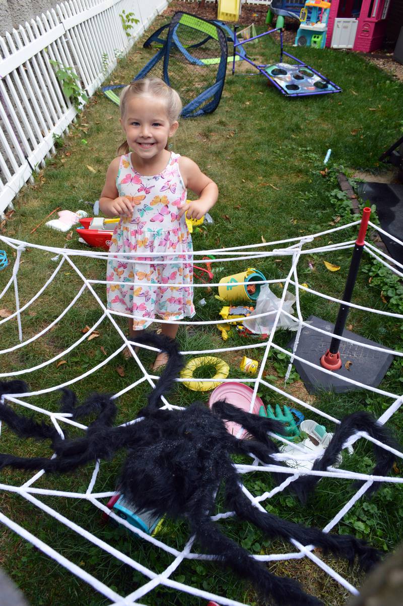 Aislynn Skinner, 4, of Oregon, stands by a giant fake spider and its web in her backyard on Sept. 6, 2023. Aislynn, who was diagnosed with a critical congenital heart defect in utero, was selected as an American Heart Association Community Youth Heart Ambassador for the 2023-24 school year.