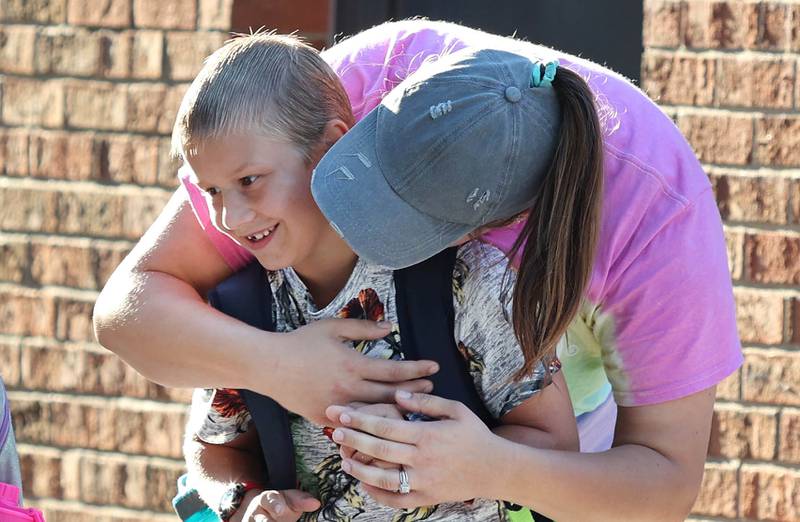 Hannah Lamothe gives her son Wesley a kiss goodbye on his first day of second grade as he waits for his bus to Kingston Elementary School Tuesday, Aug. 16, 2022, in front of Genoa Elementary School.