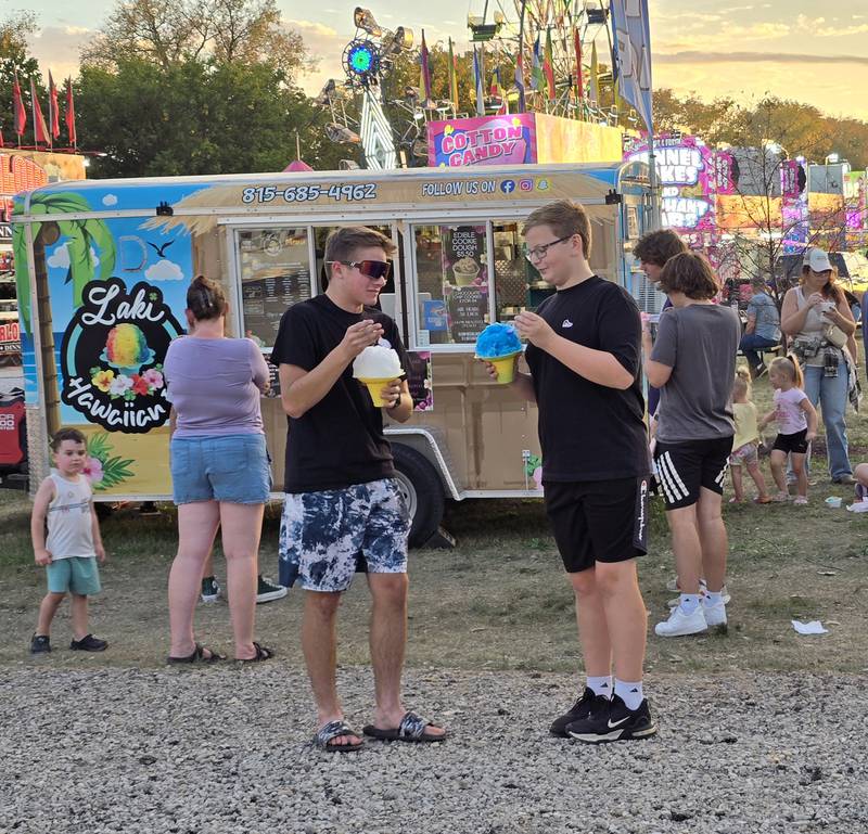 Nicholas O'Boyle (right) enjoys a snow cone Saturday, Sept. 21, 2024, with William at Seneca Days carnival.