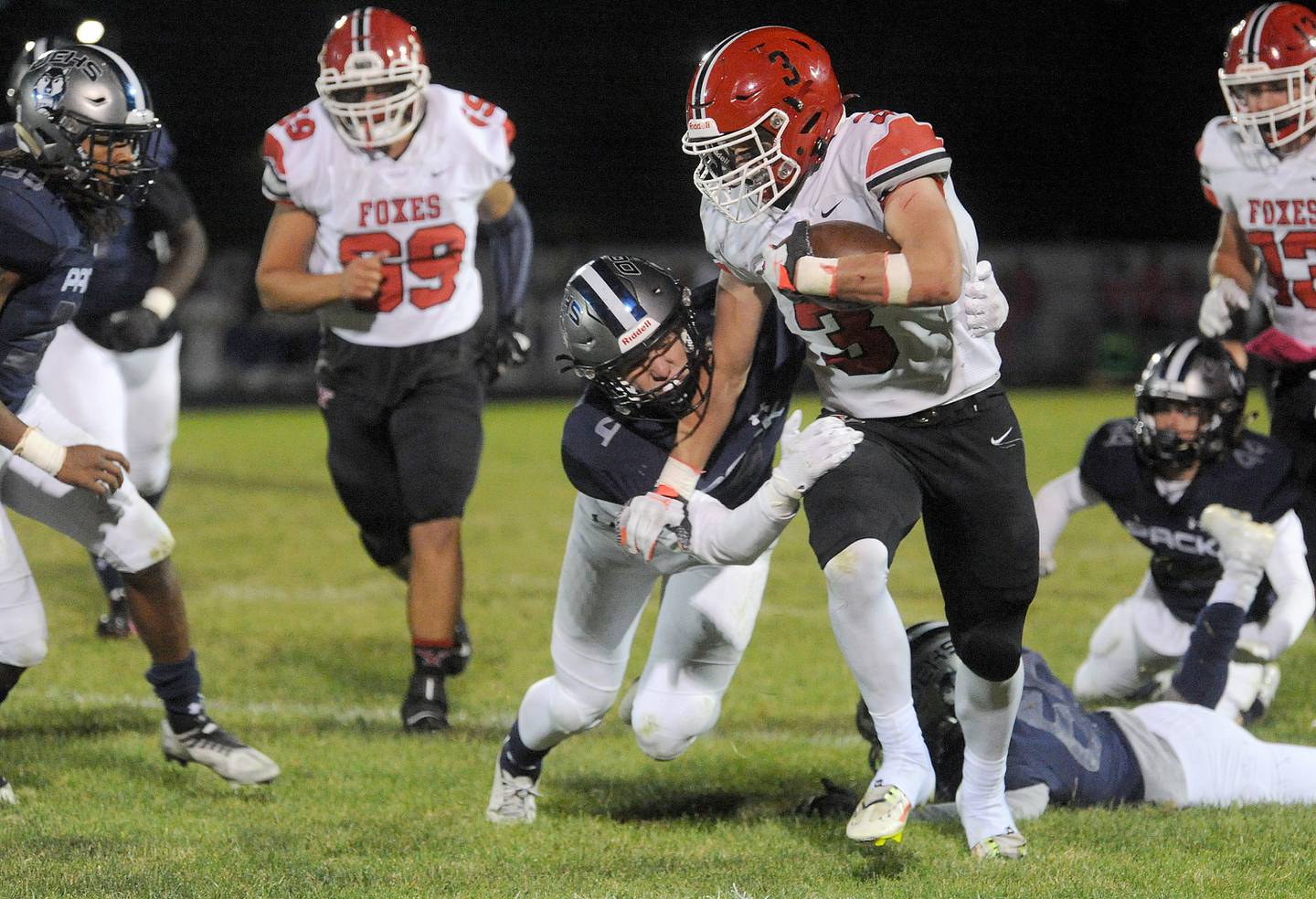 Oswego East defender Maxwell Schwertley gets his hands on Yorkville running back Josh Gettemy (3) during a varsity football game at Oswego East High School on Friday, Oct. 7, 2022.