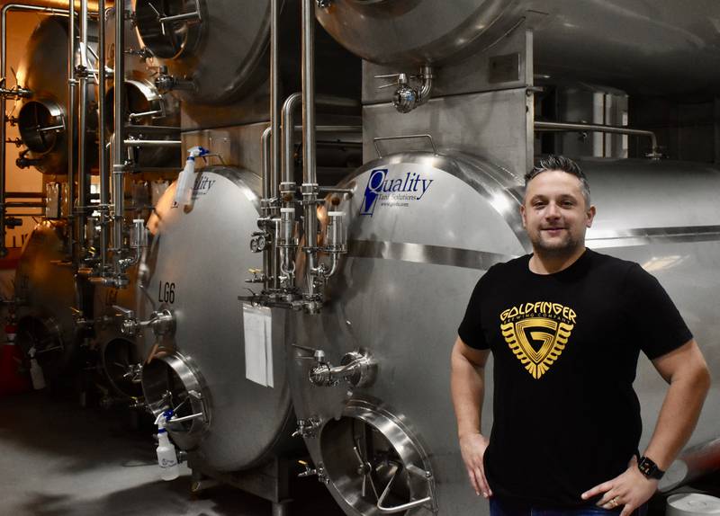 Goldfinger Brewing owner and brewer Tom Beckmann is thrilled his Downers Grove business has won worldwide acclaim. Each vat behind him holds 500 gallons of beer.