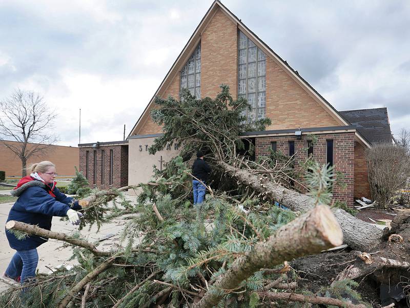 Terri Nilles, of Marseilles, volunteers her time to help remove branches from a fallen tree that blocked the entrance to St. Mary's Church in Naplate. The church has roof and shingle damage on Wednesday, March 1 2017 in Naplate.