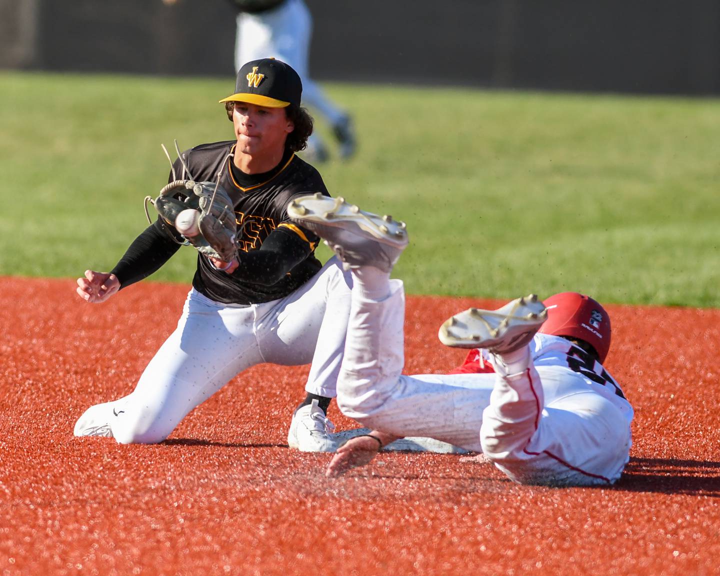 Joliet West's Nate Consalvo, left, tries to tag out Yorkville Aaron Klemm (22) as Aaron stole second base during the game on Tuesday April 8, 2025, held at Yorkville High School.