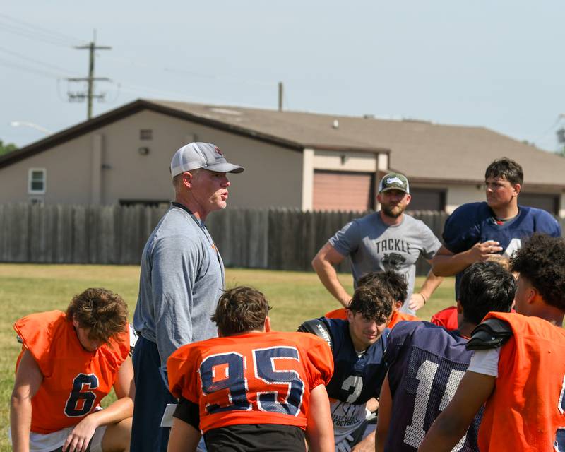Oswego’s varsity head football coach Brian Cooney, left, talks with the team after completing a joint practice with kaneland High School on Thursday July 10, 2025, held at Oswego High School.