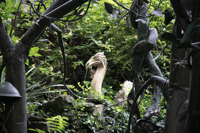 Sculptures peak through the leaves in the secret garden behind the Rainmaker studio in Makanda.