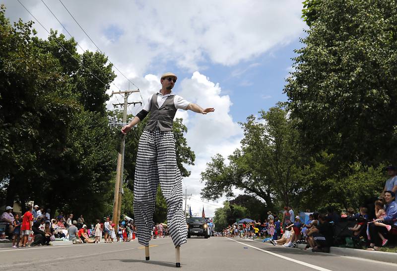 A stilt waker waves to the crowd on Sunday, July 6, 2024, during Crystal Lake’s annual Independence Day Parade on Dole Avenue in Crystal Lake.