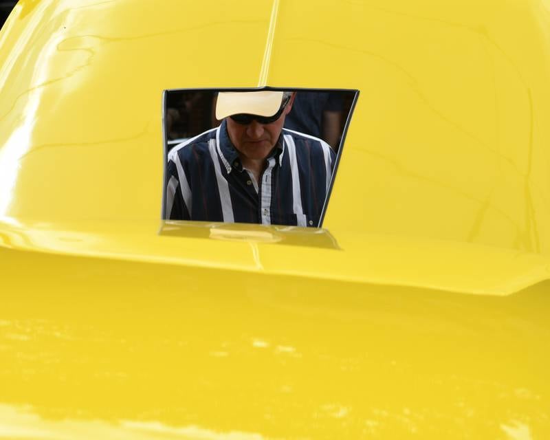 Gene Riha of Naperville looks at the engine of a Chevy Bel Air on Sunday July 27, 2025, during the Turning back time car show held in downtown Sycamore.