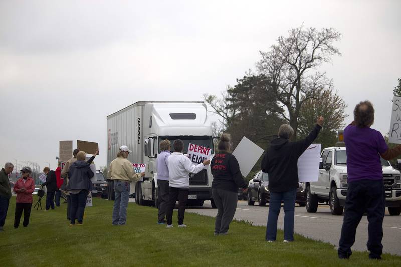 People hold up signs on Thursday, May 1, 2025, for a democracy rally in Joliet with signs critical of U.S. President Donald Trump. More than 20 people attended the rally held near the busy West Jefferson Street and the Joliet Regional Airport.