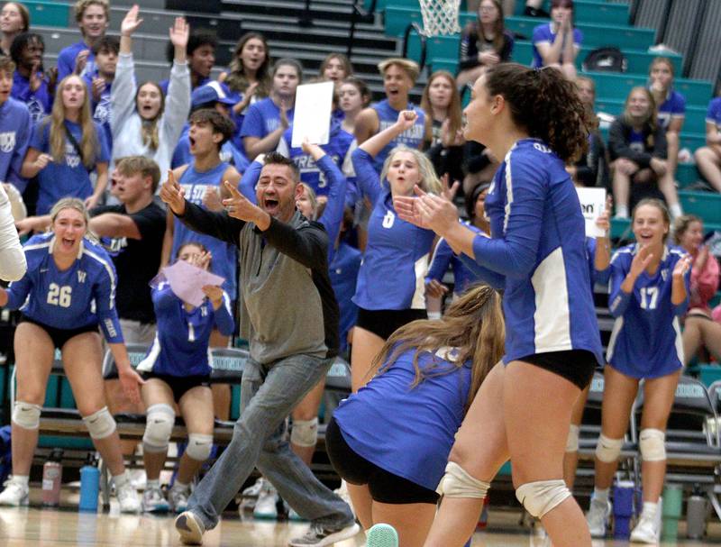 Woodstock’s coaches and players get excited after a point in varsity volleyball at Woodstock North on Monday night.