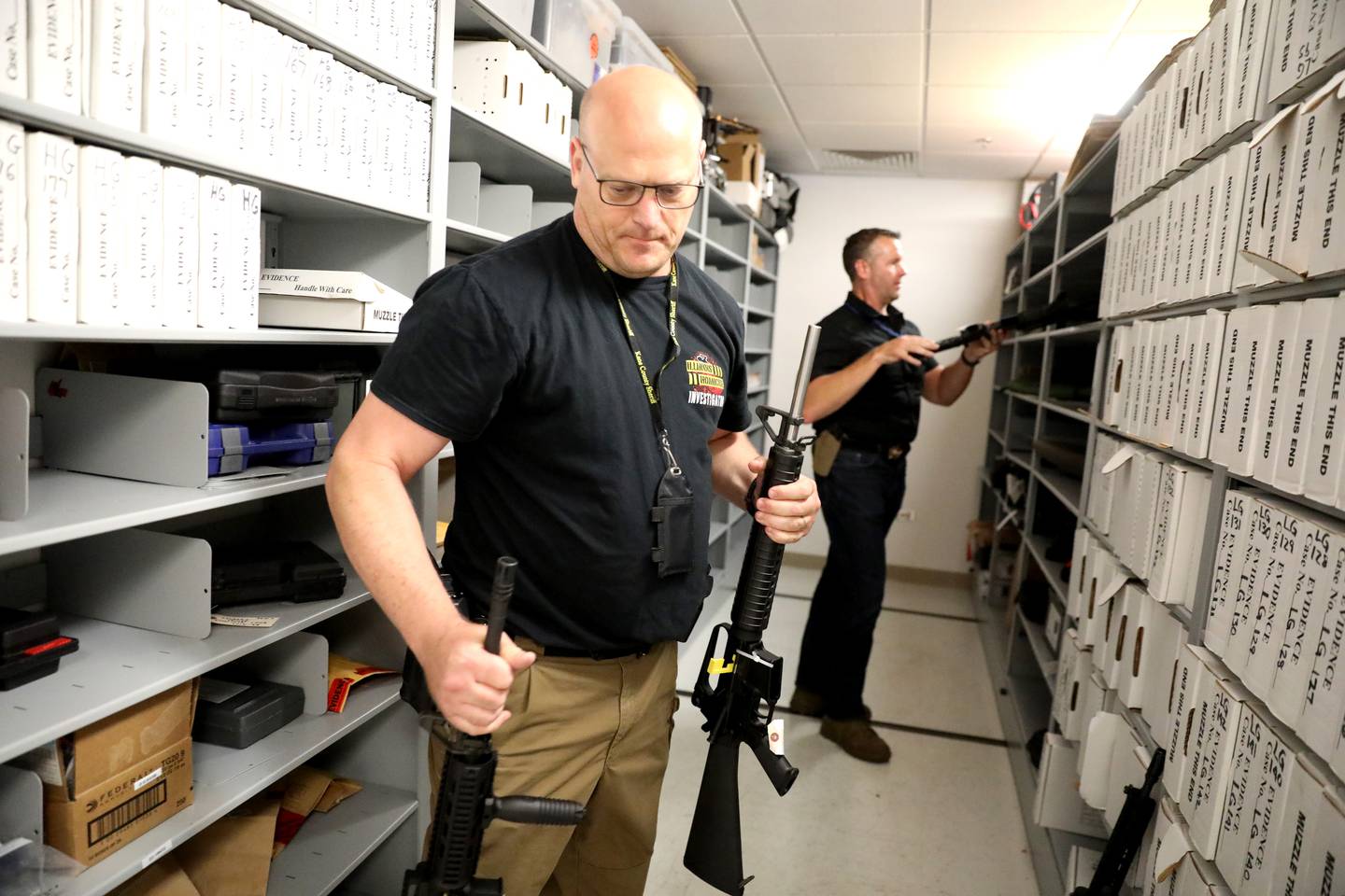 Det. Dave Thorgesen (left), evidence technician, and Kane County Sheriff Ron Hain show some of the weapons the department has in storage that were obtained due to domestic violence reports and orders of protection.