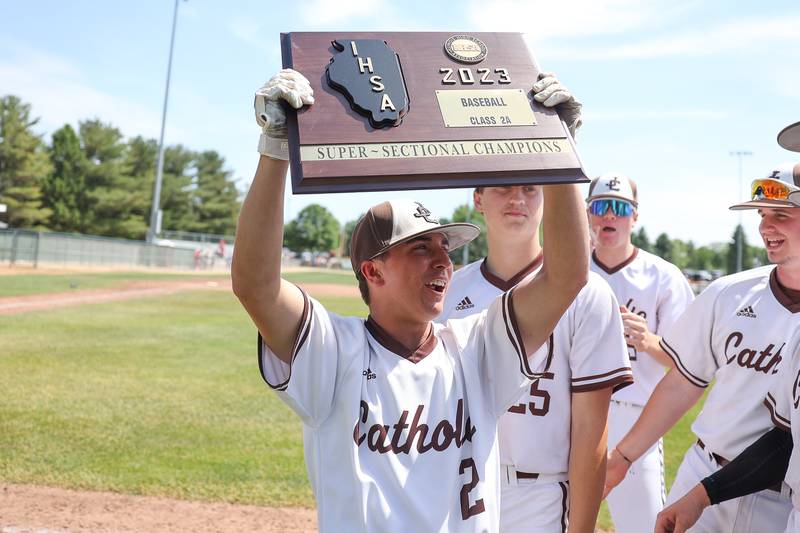Joliet Catholic’s Tommy Kemp holds up the super sectional plaque after the Hilltoppers 14-4 win against Spring Valley Hall in the Class 2A Geneseo Supersectional on Monday, May 29, 2023 in Geneseo.