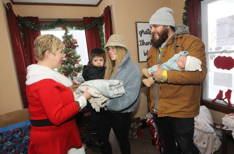 Candace H. Johnson for Shaw Local News Network
April Soulak-Andrews, of Antioch, president and founder, receives a blanket from Katie and Adrean Buster, of Antioch and their children, Logan, 2, and Roguelynn, 1-month-old, during The Penny’s Purpose Annual Blanket Drive in Antioch. (12/17/22)