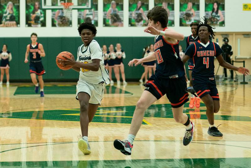 Waubonsie Valley's Tyreek Coleman (12) drives to the basket against Oswego’s Josh Nelson (10) during a Waubonsie Valley 4A regional semifinal basketball game at Waubonsie Valley High School in St.Charles on Wednesday, Feb 22, 2023.