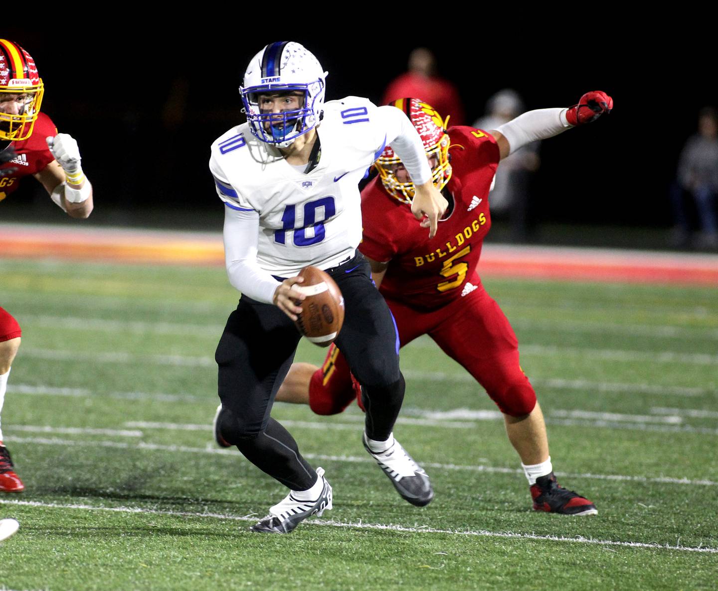 St. Charles North quarterback Ethan Plumb scrambles with the ball in the first quarter during a game at Batavia on Friday, Oct. 21, 2022.