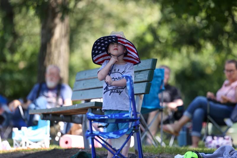 Logan Damrat, 3, of Plainfield, holds on to his has as he watches the boat races Sunday, Aug. 31, 2025, during the Kankakee River Valley Regatta.