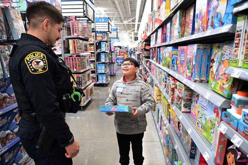 Leonardo Bravo, 9, of Carpentersville picks out a game with the help of Carpentersville Police Officer Alberto Villarreal during the Dundee Township Shop with a Cop event at Walmart on Saturday, Dec. 14, 2024 in Carpentersville.