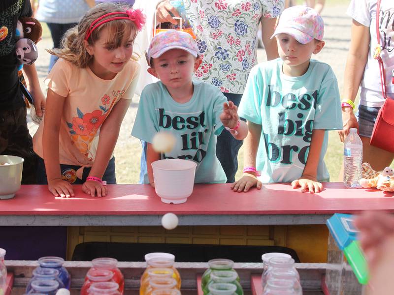 Braelyn Mays, 8, of Round Lake and her brothers, Malakai, 5, and Maverick, 7, play to win at Kristy's Pet Shop during Wauconda Fest in Wauconda. The siblings won two hermet crabs and a goldfish. (6/26/22)