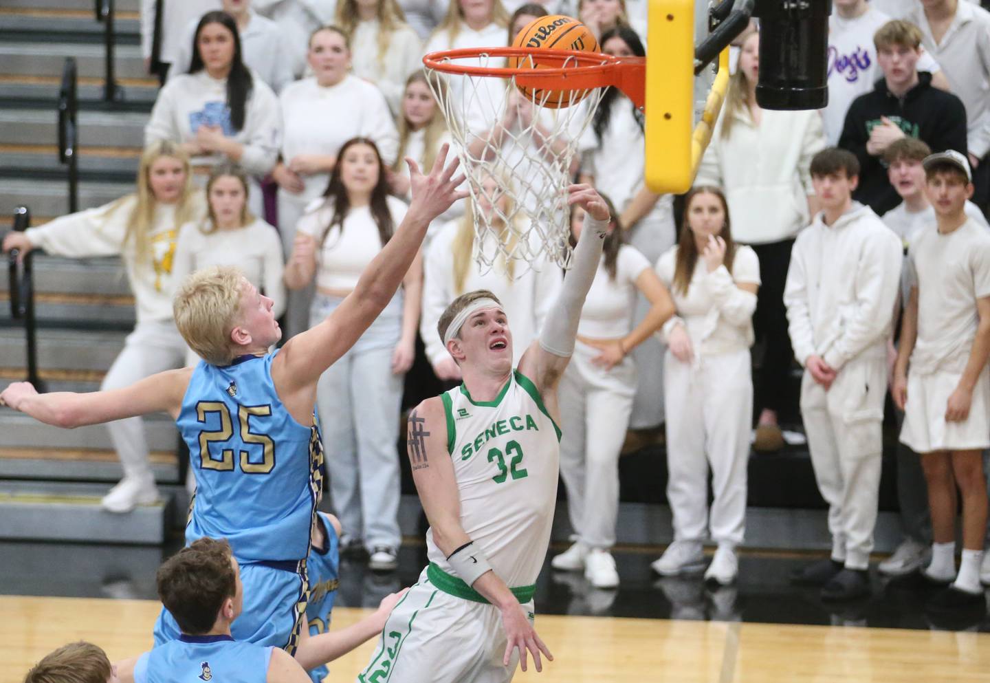 Seneca's Paxton Giertz scores on a layup over Marquette's Luke McCullough during the Tri-County Conference Tournament championship game this past season at Putnam County High School.