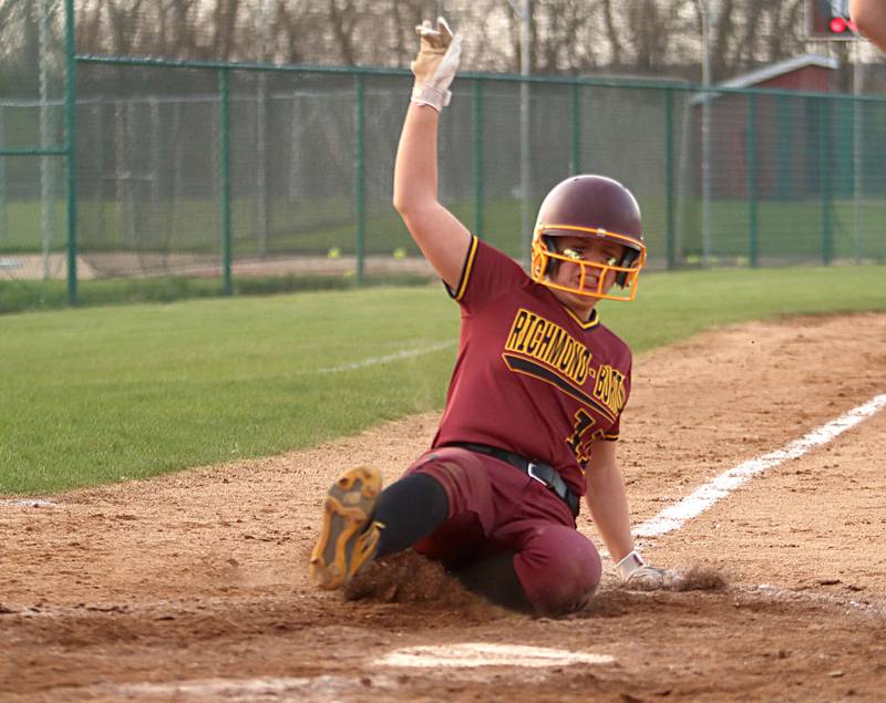 Richmond-Burton’s Sydney Hird slides across home plate safely with the go-ahead run in an extra-inning win in varsity softball at Marengo Wednesday evening.