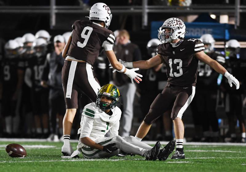 Fremd's Marquan Brewster looks away as Mount Carmel's Isaac Saldana, left, and Dean Kemph celebrate after the Vikings failed to complete a pass for a fourth-down conversion during the IHSA Class 8A football semifinal game on Saturday, Nov. 22, 2025 in Chicago.