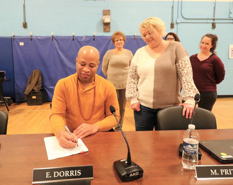 Joliet Public Schools District 86 Board of School Inspector President Erick Deshaun Dorris signs the contract with Council #86 of the American Federation of Teachers - Local 604 President Theresa Skwarczynski.