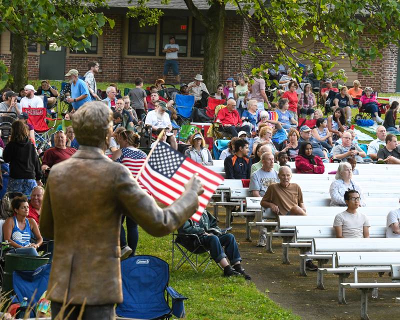 Concert goers sit in front of the Dee Palmer Band Shell at Hopkins Park in DeKalb on Monday July 4, 2022 to celebrate the Fourth of July.