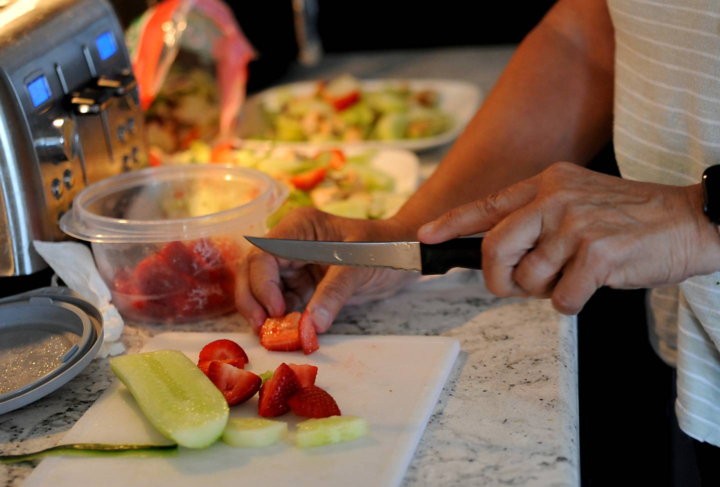 Kathy Wendhack prepares dinner for her husband, Kurt, on Tuesday, June 21, 2022, using leftover barbecue chicken and strawberries that she purchased with a digital coupon at their home in Del Webb's Sun City neighborhood in Huntley. Wendhack is trying to fight inflation by using coupons and tricks to make meals last longer.