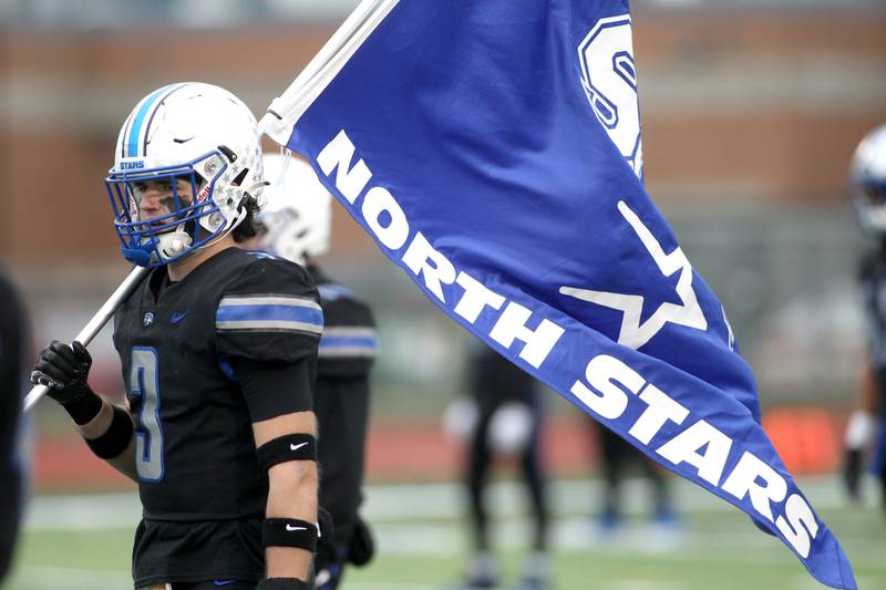 St. Charles North's Jeffrey Swanson (3) holds the North Stars flag before their 7A quarterfinal game against St. Rita in St. Charles on Saturday, Nov. 12, 2022.