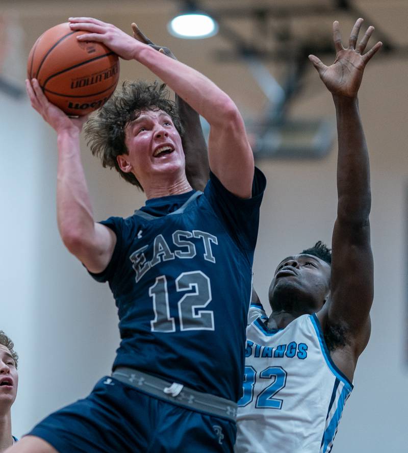 Oswego East's Ryan Johnson (12) shoots the ball in the post against Downers Grove South's Brandon Amaniampong (32) during the hoops for healing basketball tournament at Naperville North High School on Monday, Nov 21, 2022.