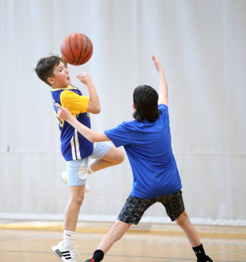 Nicholas Karawan, 11, shoots the ball over Jacob Stary, 12, during the Middle School Gym Jam at the Downers Grove Park District Recreation Center on Thursday, Jan. 4, 2024.